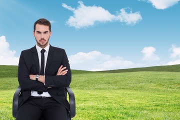 Sticker - Composite image of serious businessman sitting with arms crossed