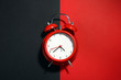 new red clockwork alarm clock on a black and red background