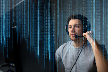 man in headset playing computer video game at home