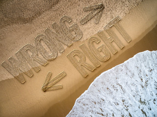 Right - Wrong written on the beach