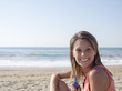 © aljndr - happy pretty woman smiling in the beach wearing a pink top with the sea and horizon in the background,