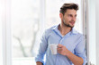© pikselstock - Man drinking cup of coffee near window