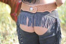 The Rear View Of Cowgirl Bum In Leather Cowboy Chaps And Belt