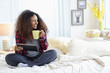 © JGI/Tom Grill/Blend Images - Black woman using digital tablet on bed