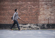 © JGI/Tom Grill/Blend Images - Mixed race man walking near brick wall