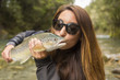 © Steve Smith/Blend Images - Caucasian woman kissing fish in remote river