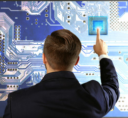 Wall Mural - Man with microchip and electronic circuit board, close up