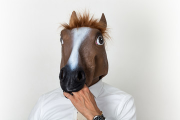 Wall Mural - Businessman closeup portrait wearing horse head and biting his hand