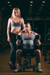 © satyrenko - beautiful young sporty sexy couple showing muscle and workout in gym dumbbell