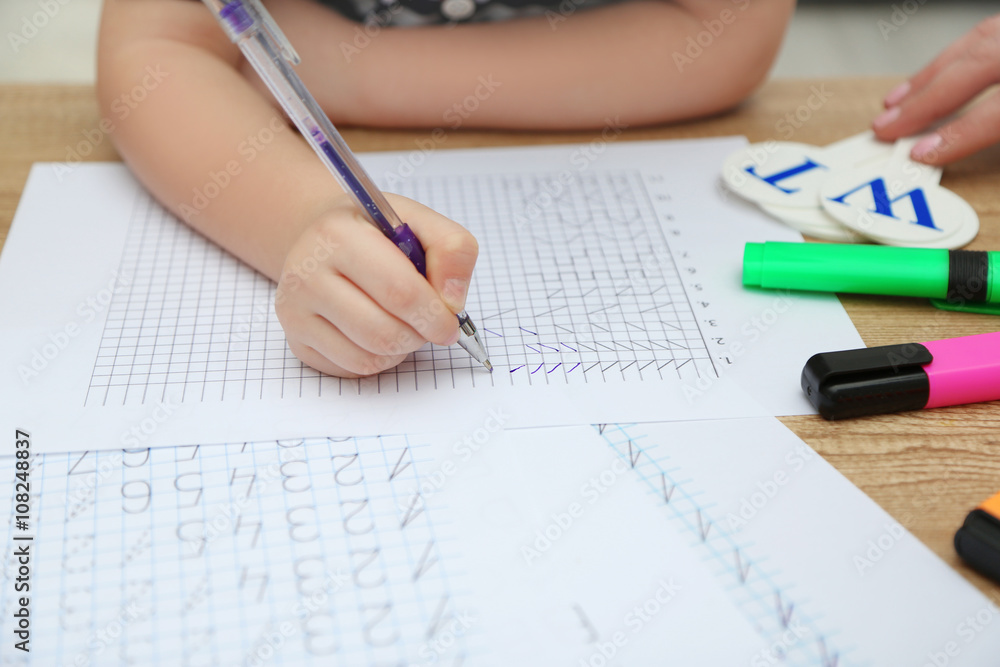 Little girl learning to draw at the table