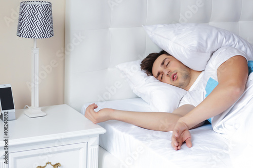 Young Man Sleeping On Comfortable Bed With Pillow On His Head