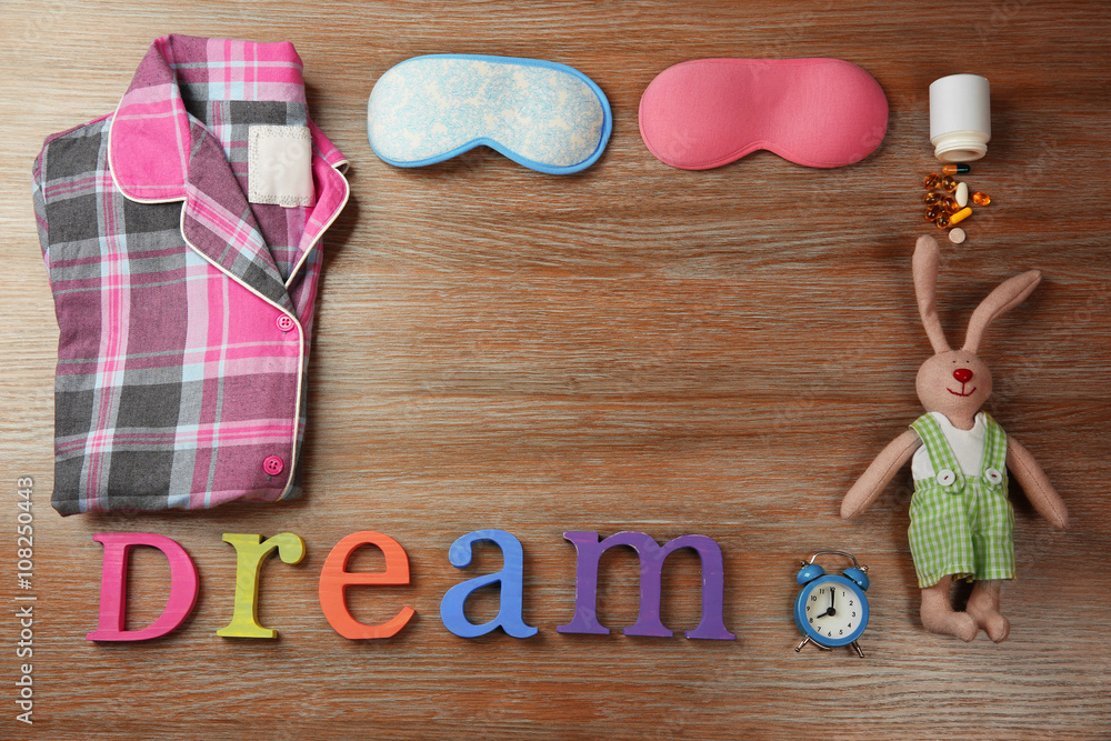 Insomnia concept with sleeping accessories on wooden table, top view