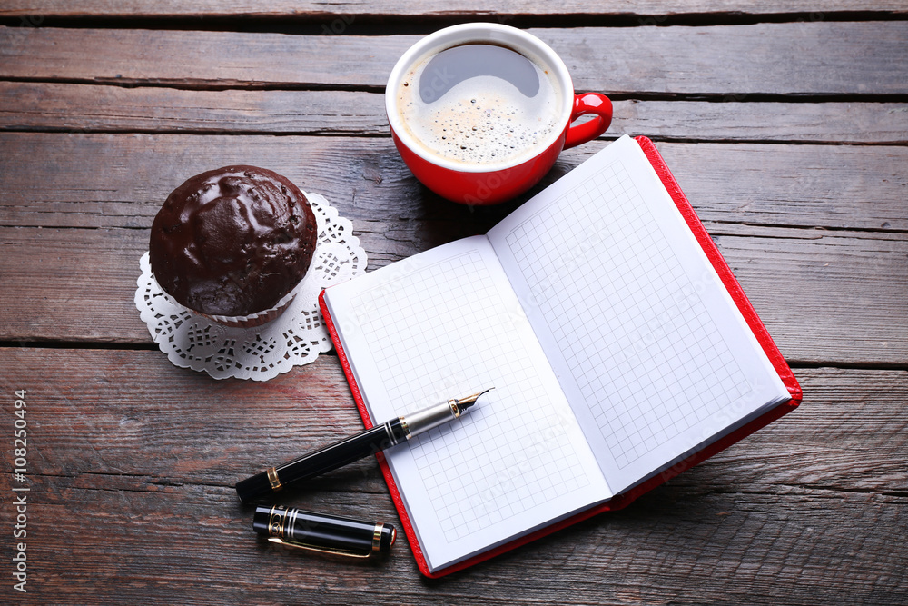 Cup of coffee with chocolate cake and open blank notebook on wooden background