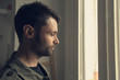 © Jesus Calonge/ADDICTIVE STOCK - Man looking out the window
