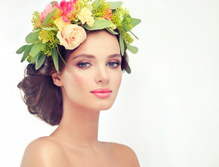 Beautiful woman model brunette with long curly hair floral wreath on the head . Spring girl . Summer fresh image .

