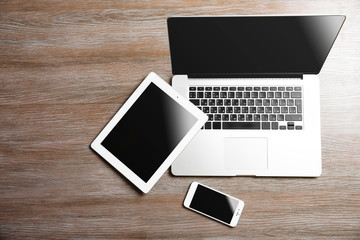 Poster - Modern laptop, smart phone and tablet on a wooden table