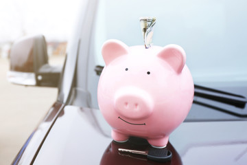 Poster - Piggy money box with cash and key on car bonnet at the street