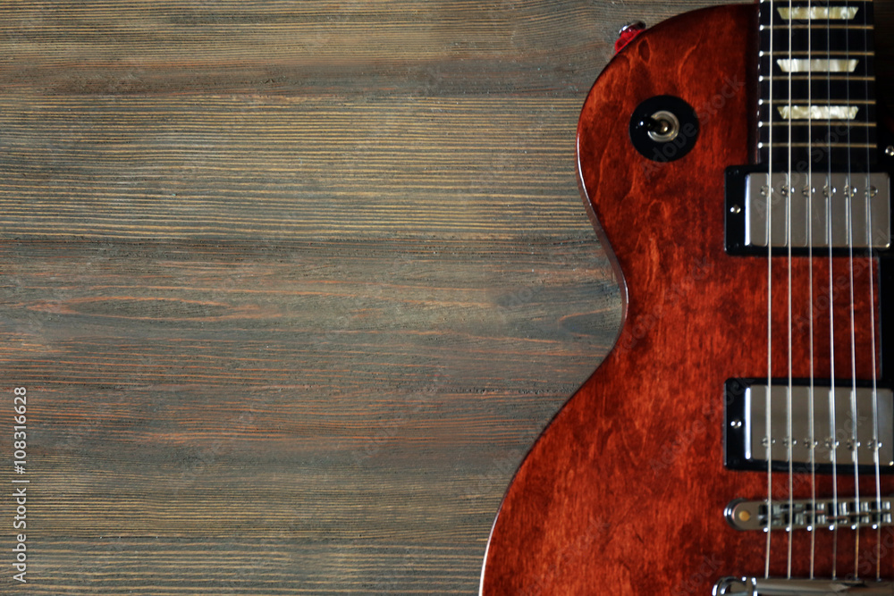 Brown electric guitar on wooden background