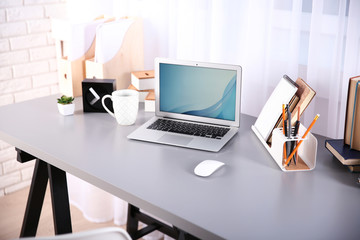 Wall Mural - Workplace with laptop, table and books beside the window