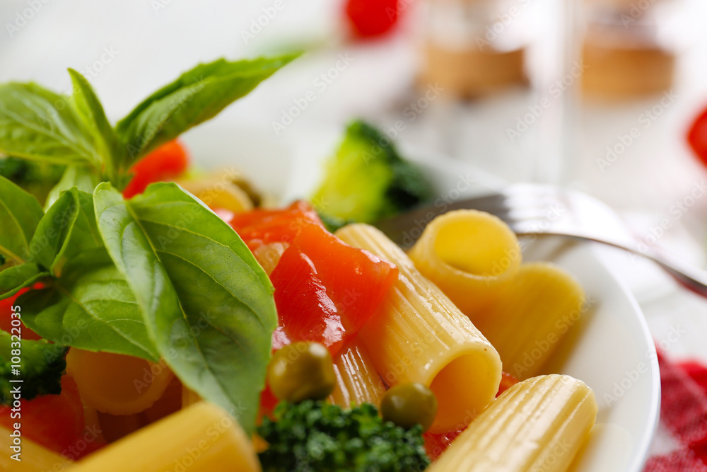 Plate of pasta with salmon and broccoli on table closeup