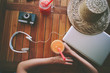 Freelance woman and the table with fresh juice, laptop, film camera, mobile phone and headphones (intentional vintage color)