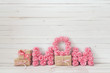 Mothers day message of pink paper flowers over white wooden boar