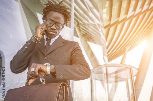 Fotografie, Obraz Black businessman delayed checking the time in the watch while he is making a te