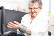 Mierzenie ciśnienia krwi.
Starsza kobieta mierzy ciśnienie domowym ciśnieniomierzem nadgarstkowym.
