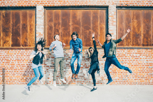 Valokuva Group of young beautiful multiethnic man and woman friends having fun jumping ou