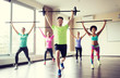 © Syda Productions - group of people exercising with bars in gym