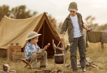 Two of children sitting around the campfire travelers