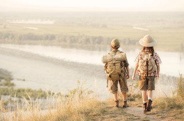 Children with tourists on a cliff at sunset