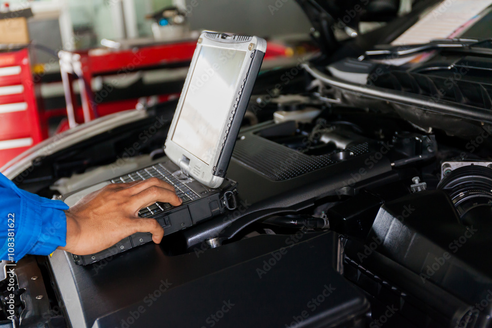 Mechanic using Diagnostic machine tools ready to be used with car