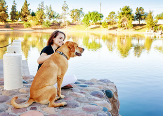 Wall Mural - girl and dog at lake in park