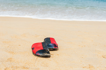 Shoes on white sand beach in day noon light