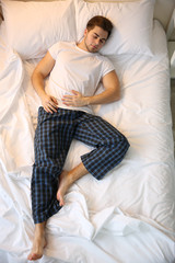 Wall Mural - Young man sleeping in bed at home