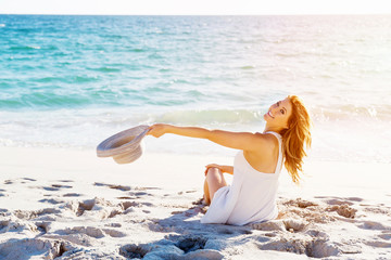 Poster - Young woman sitting on the beach