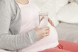 Schwangere hält Wasser in Hand