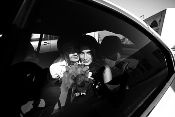 Happy beautiful newlyweds in the car b&w