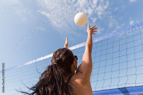 Fotomural Mujer joven con la bola de la práctica del voleibol en la playa