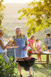 © luckybusiness - grandfather drinking wine by the barbecue.