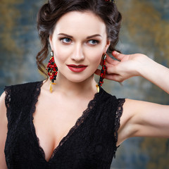 Wall Mural - Elegant young woman with perfect makeup and hair style in a black dress with diadem and earrings. Beauty fashion portrait with accessories