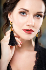 Wall Mural - Elegant young woman with perfect makeup and hair style in a black dress with diadem and earrings. Beauty fashion portrait with accessories