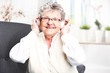 Babcia słucha muzyki. Starsza kobieta z słuchawkami na uszach słucha muzyki