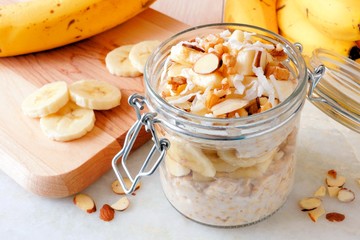 Wall Mural - overnight oats with bananas and nuts in snap lid glass jar on white marble