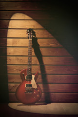 Wall Mural - Electric guitar on dark lighted wooden background