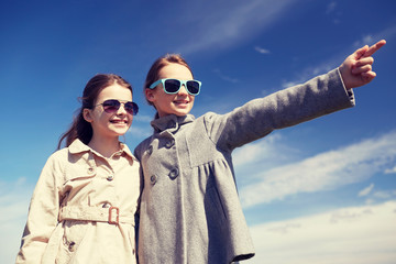 Poster - happy little girls hugging and pointing finger