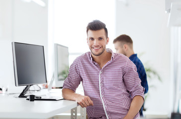 happy creative man with computer at office