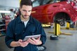 © Wavebreak Media - Mechanic using digital tablet