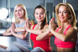 © mintybear - Four girls meditating after fitness training in gym.Group of young women in the gym centre. Yoga.